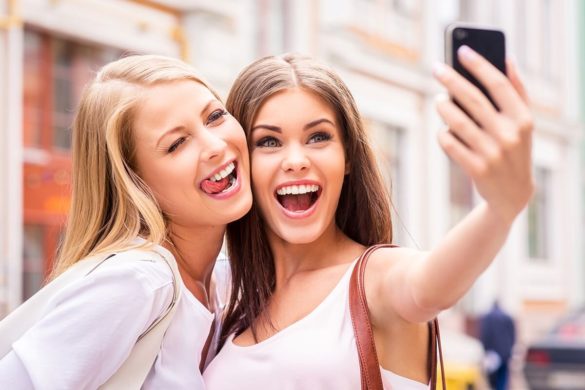 two women smiling while taking a selfie