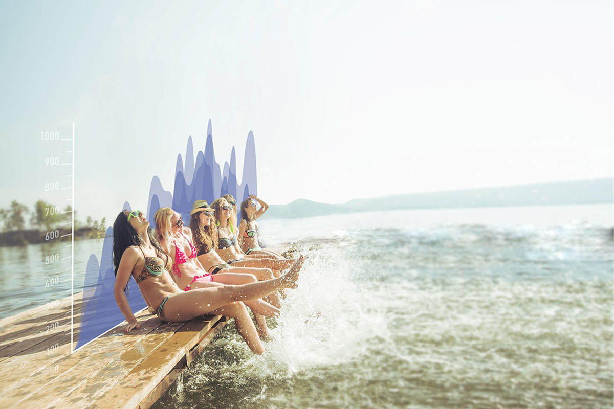 Woman sitting on a deck with their legs under water